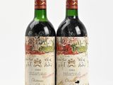 two bottles of wine sitting next to each other on a white surface