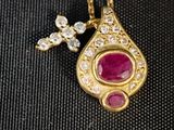 un gros plan sur un collier en or orné d'un pendentif en rubis et diamants