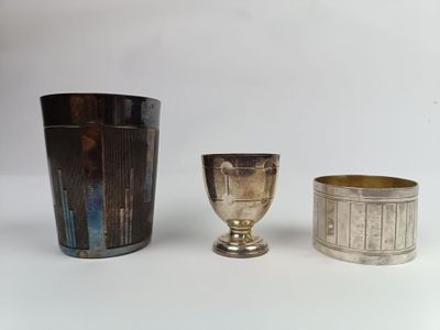 trois tasses en argent posées l'une à côté de l'autre sur une table