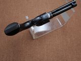 a black pipe sitting on a clear stand on a brown surface