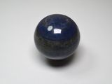 un gros plan d'une bille bleue posée sur une surface blanche