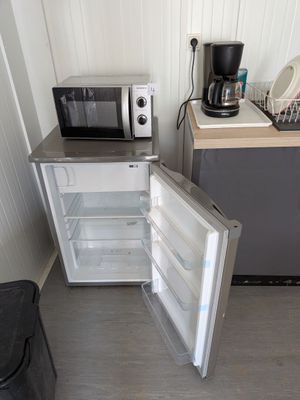 un réfrigérateur ouvert et un micro-ondes dans une petite pièce
