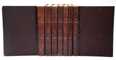 six vieux livres sont alignés sur une surface blanche