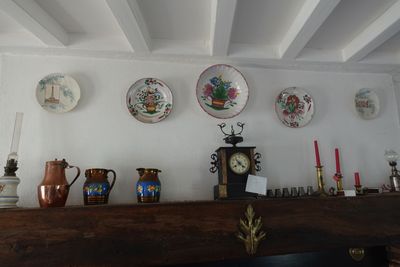 de nombreuses assiettes et vases sur la cheminée de cette pièce