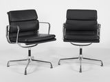 une paire de fauteuils de salon en cuir noir avec des pieds en acier chromé