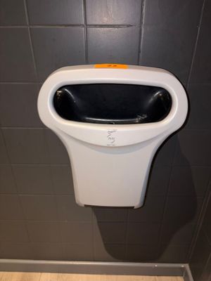 un urinoir situé dans un coin d'une cabine de toilettes