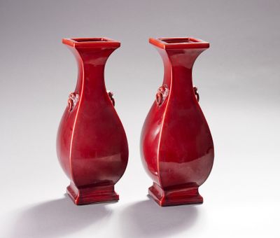 deux vases rouges posés l'un à côté de l'autre sur une table