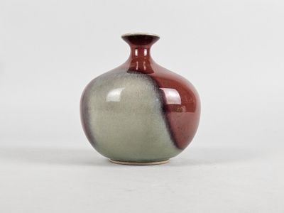 a small vase that is sitting on a white surface
