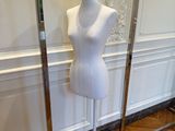 deux mannequins posés sur des socles dans une pièce au sol en parquet