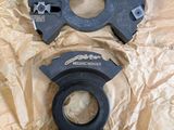 a pair of black plastic parts sitting on top of a piece of paper