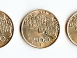 three coins are shown on a white surface with a white background