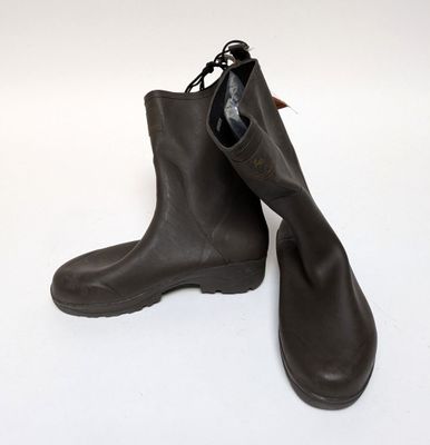 une paire de bottes en cuir marron posées sur une surface blanche, sur fond blanc
