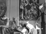 an old black and white photo of a man working on a piece of art