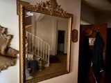 un miroir accroché au mur, à côté d'un mur sur lequel est posé un ours en peluche