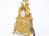 a gold clock that is sitting on top of a table