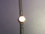 a close up of a wrist watch on a black surface