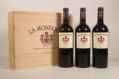 trois bouteilles de vin rouge devant une caisse en bois