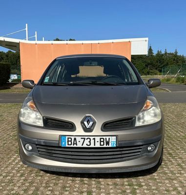 l'avant d'une voiture argentée garée sur un parking à côté d'un immeuble