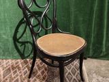 a black chair with a wicker seat on a rug