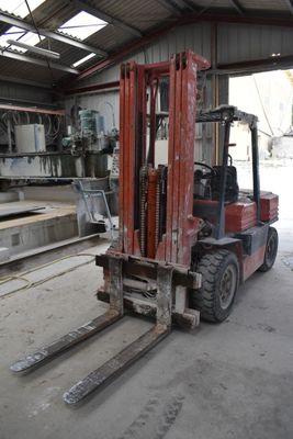 a red forklift truck parked in a warehouse