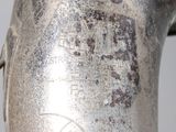 a close up of a silver vase with a label on it
