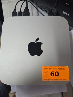 un ordinateur Apple posé sur un bureau, à côté d'un clavier