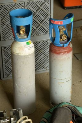 two gas bottles sitting next to each other on the floor