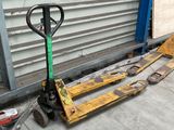 a fork and a pallet on the ground next to a garage door