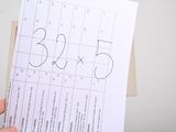 a person holding a piece of paper with numbers on it