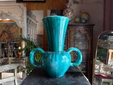 a blue vase sitting on top of a wooden table