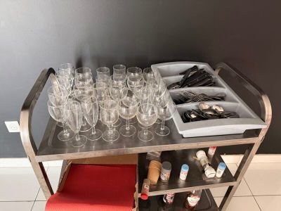 un chariot en métal sur lequel sont posés des verres à vin et d'autres objets