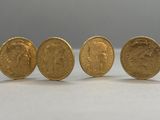 three gold sovereigns sitting next to each other on a table