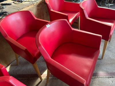 Plusieurs chaises rouges sont alignées en rang dans une pièce