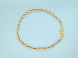 a close up of a gold and silver bracelet on a blue surface