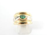 gros plan d'une bague en or avec une pierre verte