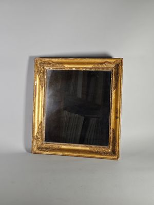 une photo d'un miroir à cadre doré accroché à un mur blanc