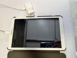 une tablette posée sur une table, à côté d'un téléphone portable