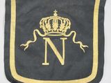 un gros plan d'un drapeau noir et or orné d'une couronne