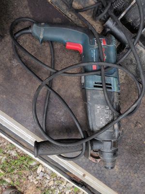 une perceuse posée par terre à côté de quelques fils électriques