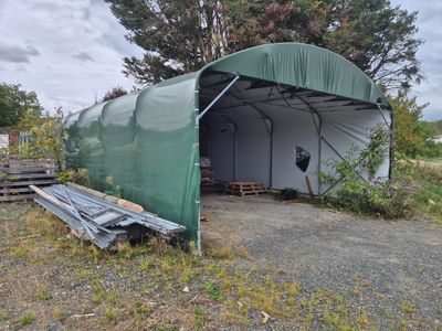 une tente verte installée au milieu d'un champ