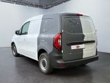 the back of a silver van parked in a room with a black floor