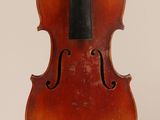un vieux violon posé sur une surface blanche, avec un archet noir