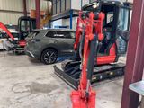a red excavator that is parked in a garage