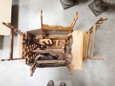 une personne debout à côté d'une pile de chaises en bois