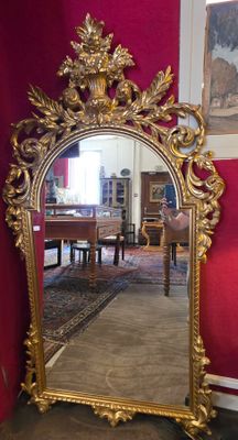 un grand miroir doré dans un coin de la pièce