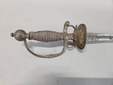an old sword with a metal handle on a white surface