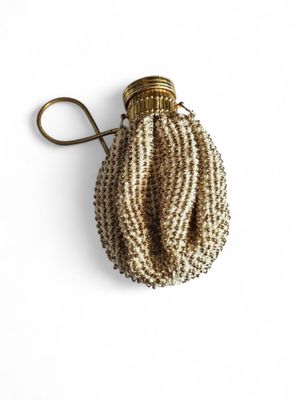 a close up of a small beaded purse on a white surface