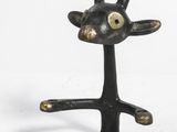 une petite statue de chèvre posée sur un socle