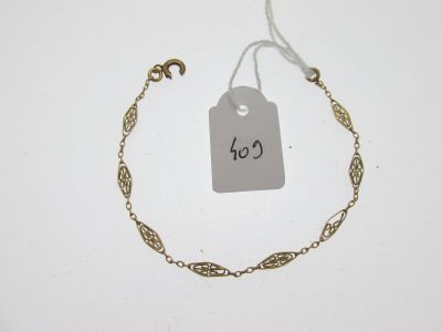 un gros plan d'un bracelet à chaîne en or sur lequel est accrochée une étiquette de prix