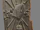 an image of a metal plaque with a sun and cross on it